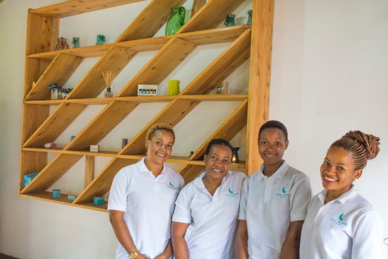 Four massage therapists smiling at camera.