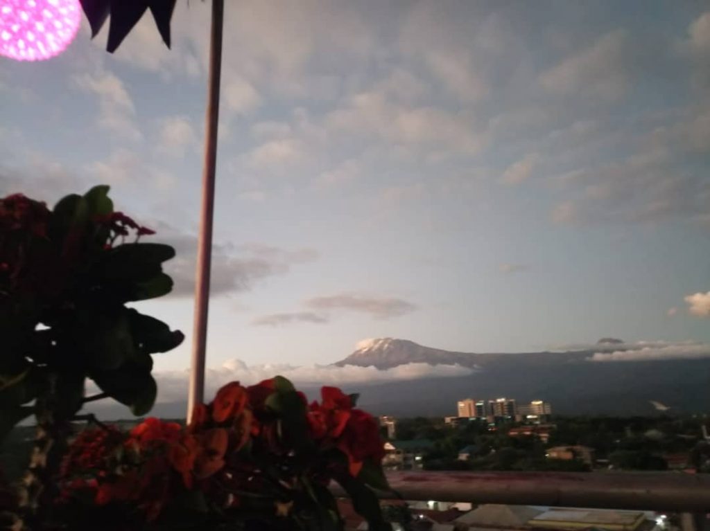 View of Moshi from the top of Selig Hotel. Sun setting on Kilimanjaro in the background.